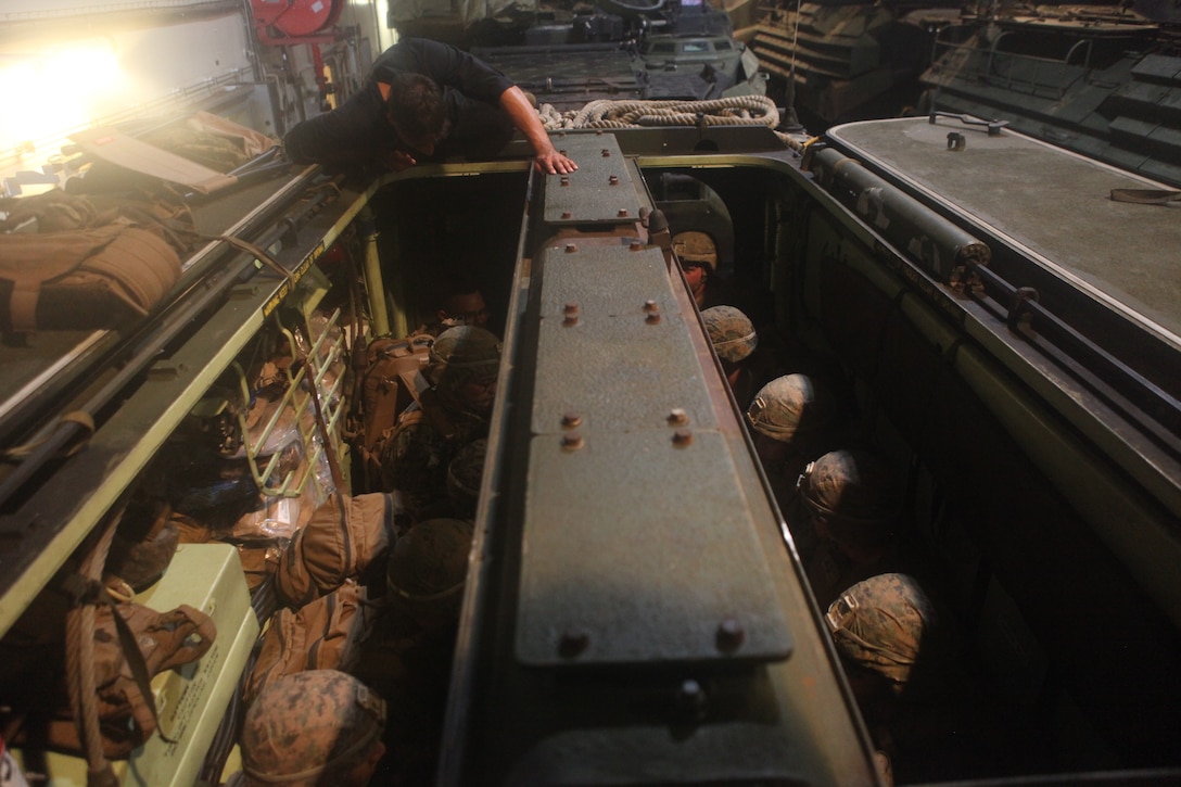 U.S. Marine Corps Cpl. Marco Martinez, a crew chief with Combat Assault Company, 3rd Marine Regiment, observes loading drills onto an AAV-P7/A1 assault amphibious vehicle aboard the Royal Australian Navy landing helicopter dock ship HMAS Adelaide (L01) as part of Rim of the Pacific (RIMPAC) exercise off the coast of Marine Corps Base Hawaii July 11, 2018. RIMPAC provides high-value training for task-organized, highly capable Marine Air-Ground Task Force and enhances the critical crisis response capability of U.S. Marines in the Pacific. Twenty-five nations, 46 ships, five submarines, about 200 aircraft and 25,000 personnel are participating in RIMPAC from June 27 to Aug. 2 in and around the Hawaiian Islands and Southern California. The world's largest international maritime exercise, RIMPAC provides a unique training opportunity while fostering and sustaining cooperative relationships among participants critical to ensuring the safety of sea lanes and security on the world's oceans. RIMPAC 2018 is the 26th exercise in the series that began in 1971. (U.S. Marine Corps photo by Sgt. Zachary Orr)