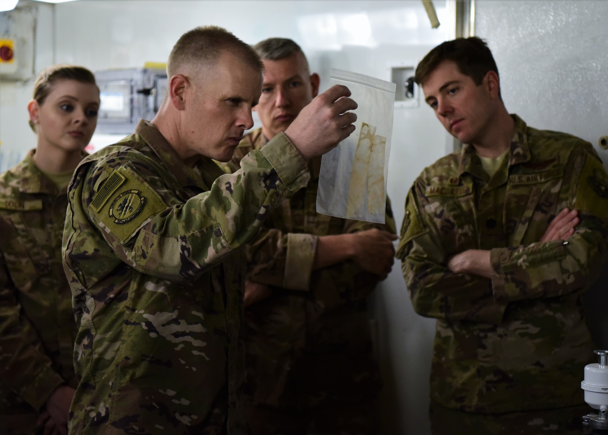 Senior Airman Paige Dixon, Chief Master Sgt. Christopher Walker, Senior Master Sgt. Brian Rohlman and Lt. Col. Mason MacGarvey, all part of the 387th Air Expeditionary Squadron, inspect blast residue during a visit to the Camp Arifjan level-II forensics lab, June 27, 2018. The 387th AES provides administrative support to more than 410 Joint Expeditionary Task and Individual Augmentee Airmen, who encompass more than 100 Air Force specialty codes and are currently forward deployed to 11 countries. (U.S. Air Force photo by Staff Sgt. Christopher Stoltz)