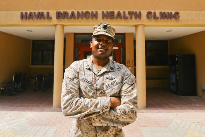 A Navy corpsman stands in front of a building.