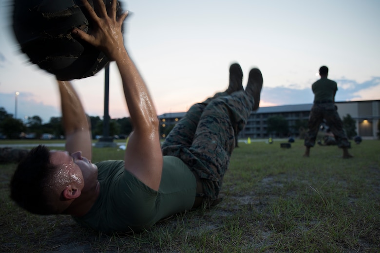 Cpl. Parker Golz conducts V-situps during a High Intensity Tactical Training class led by Force Fitness instructor, Sgt. Jared Skelley July 12 aboard Marine Corps Air Station Beaufort. Skelley specializes in creating workout routines for individual Marines focusing on functional planes of motion, combat readiness and injury prevention. Golz is a combat videographer with Headquarters and Headquarters Squadron.