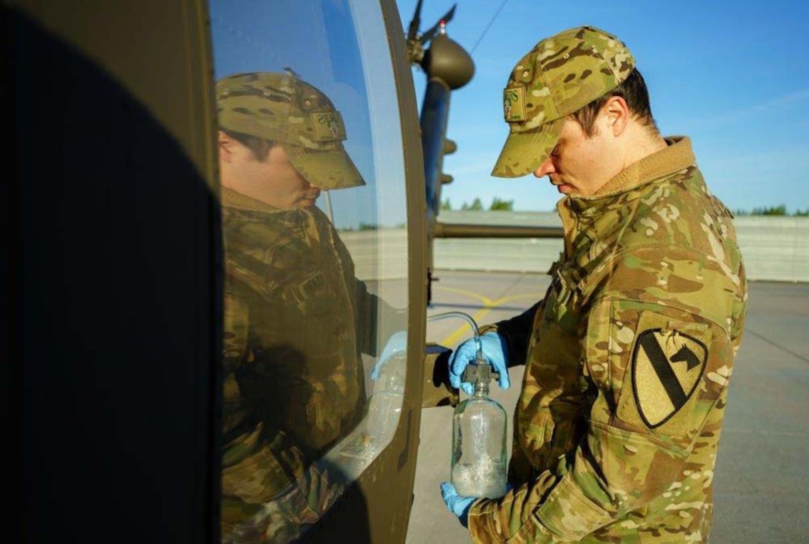 An Army soldier removes fuel from an aircraft for testing .