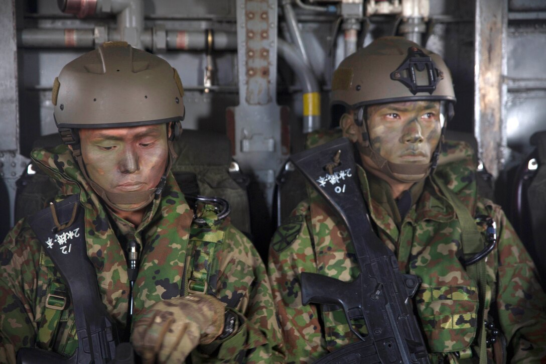 Japanese soldiers sit in a helicopter during amphibious operation.