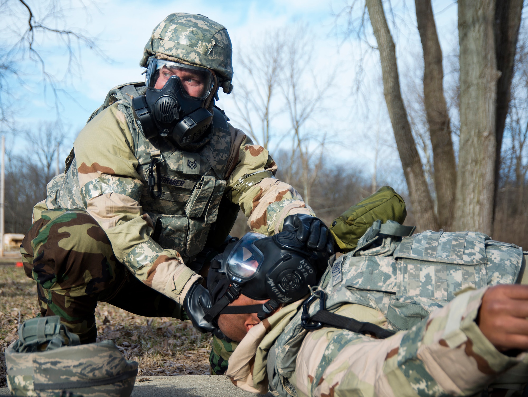 Tech Sgt. Matthew Cormier, 88th Security Forces Squadron, renders assistance to Senior Master Sgt. Himaiya Lowery, 88th SFS, Jan. 31, 2018, during a simulated chemical attack as part of an exercise on Wright-Patterson Air Force Base, Ohio. Part of the exercise was designed to train Airmen in how to protect themselves and aid others in a high-threat environment. (U.S. Air Force Photo by R.J. Oriez)