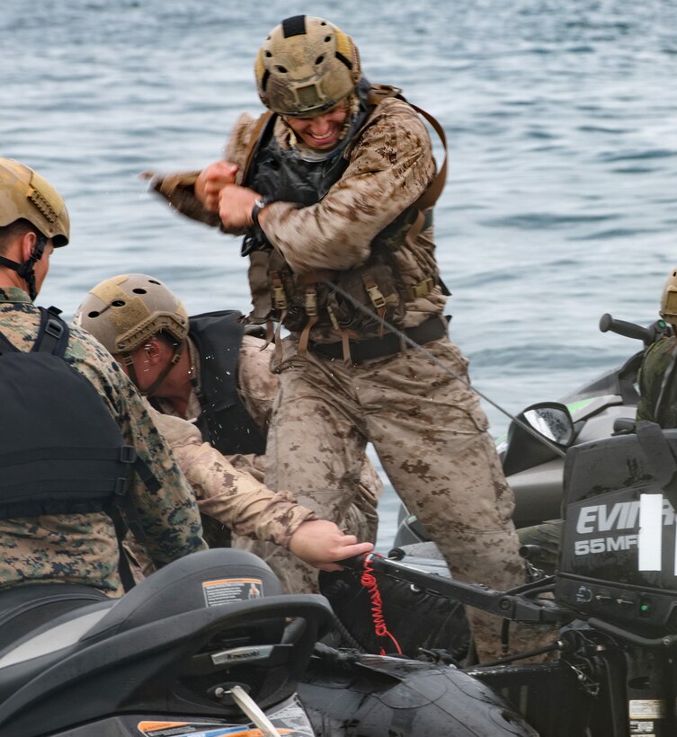 A U.S Marine starts a rigid-hull inflatable boat motor after entering the drop zone.