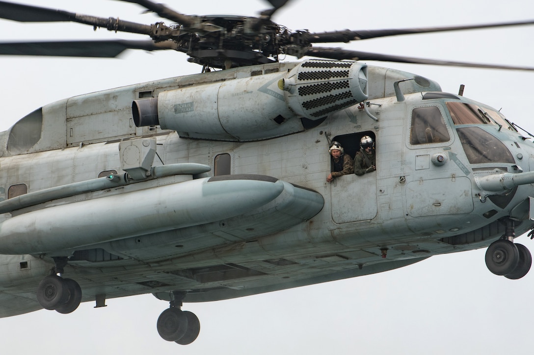 U.S Marines look out the side of a CH-53E Super Stallion helicopter during training.