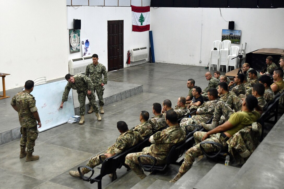 A U.S. sailor briefs U.S. and Lebanese armed forces explosive ordnance disposal technicians and divers.