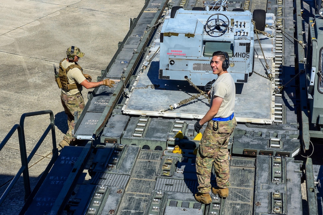 Airmen load support equipment and rolling stock onto a Boeing 747.