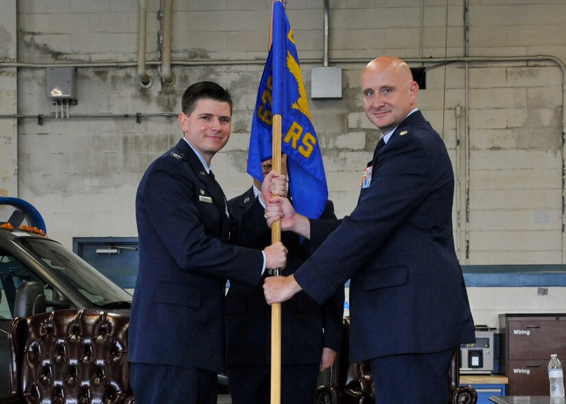 Maj. John M. Barrett, left, assumes command of the 628th Logistics Readiness Squadron from Col. Rockie Wilson, right, 628th Mission Support Group commander, during the 628th LRS change of command ceremony here, July 13, 2018.