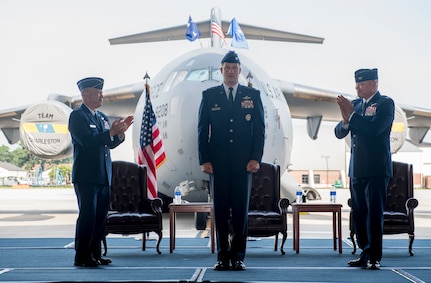 Col. Clinton R. ZumBrunnen, 437th Airlift Wing commander, is applauded by Lt. Gen. Gi Tuck, 18th Air Force commander, and Col. Jimmy Canlas, outgoing 437th AW commander, as he takes command of the 437th AW during a change of command ceremony July 12, 2018, in Nose Dock 2.