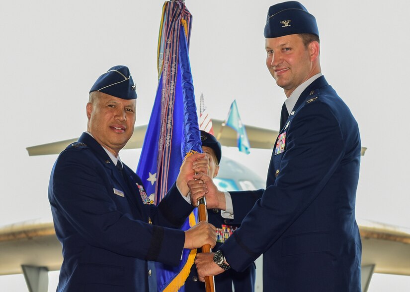 Col. Clinton R. ZumBrunnen, 437th Airlift Wing commander, receives the 437th AW guidon from Lt. Gen. Gi Tuck, 18th Air Force commander, during a change of command ceremony July 12, 2018, in Nose Dock 2.