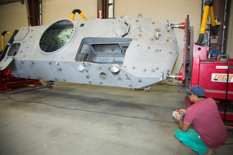 Eugene Dunford, welder, uses the controls to rotate a Light Armored Vehicle attached to the trunnion into a position to make it easier to make the numerous welds required at Production Plant Barstow, Marine Depot Maintenance Command, aboard the Yermo Annex of Marine Corps Logistics Base Barstow, June 29. Prior to the advent of the trunnion, welders had to make many overhead welds, which increased the possibility that the joints would not pass x-ray inspection.