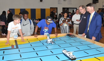 IMAGE: KING GEORGE. Va. (June 25, 2018) - Rep. Rob Wittman (R-Va.) observes middle school students deploy a robot they designed, built, and programmed to deliver humanitarian aid, rotate troops and transport an electromagnetic railgun to the deck of a Navy ship at the 2018 STEM Summer Academy. Students briefed their mentors, teachers, and visitors, including Wittman, on how they overcame a variety of Navy focused problems by designing, building, and programming LEGO Mindstorm robots to solve a variety of Navy focused problems.