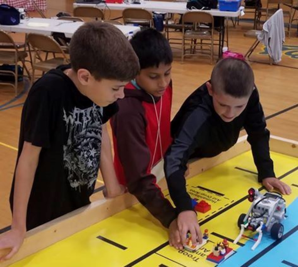 IMAGE: KING GEORGE. Va. (June 28, 2018) - Middle school students prepare to deploy a robot they designed, built, and programmed to deliver humanitarian aid, rotate troops and transport an electromagnetic railgun to the deck of a Navy ship at the 2018 STEM Summer Academy. The students briefed their mentors, teachers, and visitors on how they overcame a variety of Navy focused problems by designing, building, and programming LEGO Mindstorm robots to solve a variety of Navy focused problems.