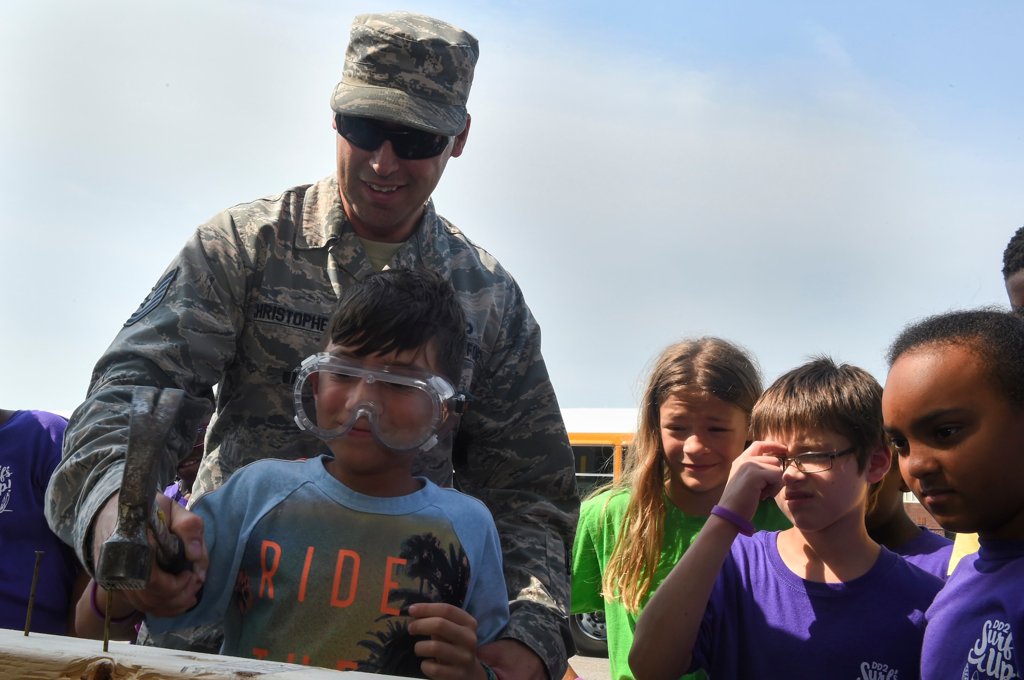 Tech. Sgt. John Christopher, 628th Civil Engineer Squadron structural NCO in charge, teaches Ethan Burke, age 9, how to properly hammer a nail into a plank of wood July 12, 2018, at the emergency management building at Joint Base Charleston, S.C.