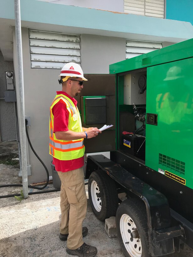 A member of the Pittsburgh District temp. power team inspects a generator at a facility.
