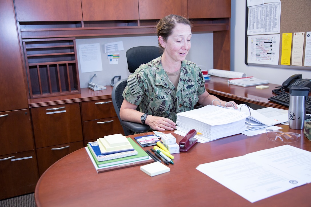 Lieutenant Commander Jamie Rivas studies one of the many "turnover" binders to get up to speed in her new role as Public Works Officer, aboard Marine Corps Logistics Base Barstow, Calif.,  July 2. The native of Bryan, Ohio, is taking over for outgoing LCDR Jeffrey Patton.
