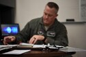 Maj. Drew Walters, 41st Flying Training Squadron instructor pilot looks over papers before briefing student pilots July 2, 2018, on Columbus Air Force Base, Mississippi. Instructor pilots drill students on in-flight emergency procedures constantly throughout training so in the event of a real emergency, the pilots are able to evaluate and react as fast as possible. (U.S. Air Force photo by Airman 1st Class Keith Holcomb)