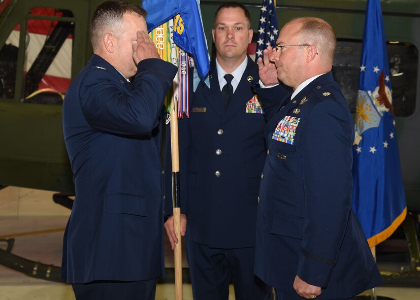 Lieutenant Colonel James Cline renders a final salute to 582nd Helicopter Group Col. Joshua Bowman before relinquishing the guideon in the 37th Hangar Bay at F.E. Warren Air Force Base, Wyo., July 13, 2018. Cline turned over command of the group to Lt. Col. Adam Rudolphi during the ceremony, which represents a formal transition of authority from the outgoing commanding to the incoming commander. (U.S. Air Force photo by Glenn S. Robertson)