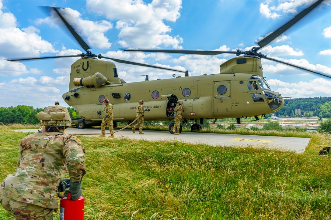 Soldiers move around a Chinook helicopter.