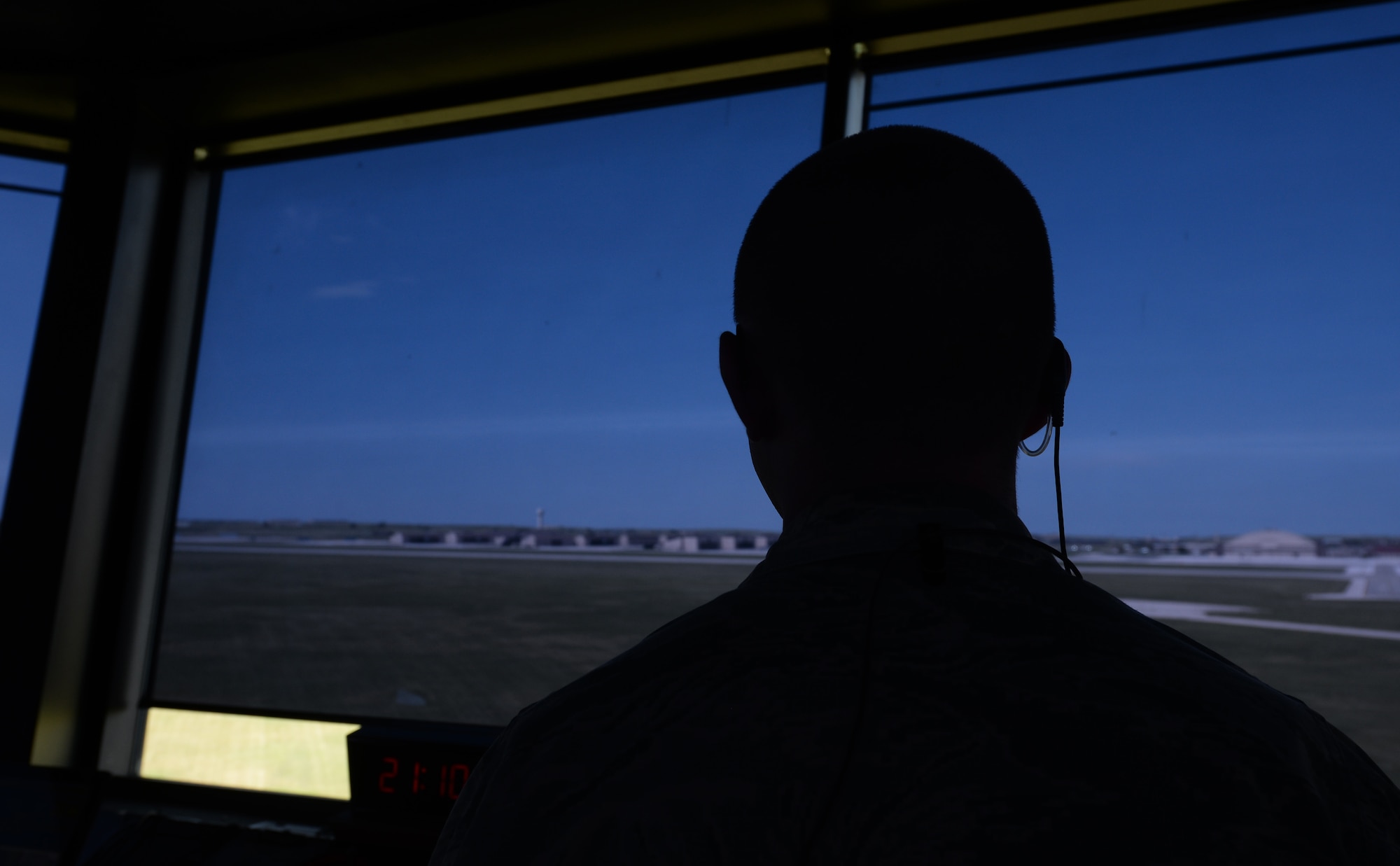 Senior Airman Grant Krause, a 28th Operations Support Squadron air traffic control journeyman, looks at the flight line through blue shaded blinds inside the air traffic control tower at Ellsworth Air Force Base, S.D., July 10, 2018. Due to the high-stress nature of the job, the air traffic controller’s technical training attrition rate is only 50 percent, making the success of their job even more crucial. (U.S. Air Force photo by Airman 1st Class Nicolas Z. Erwin)