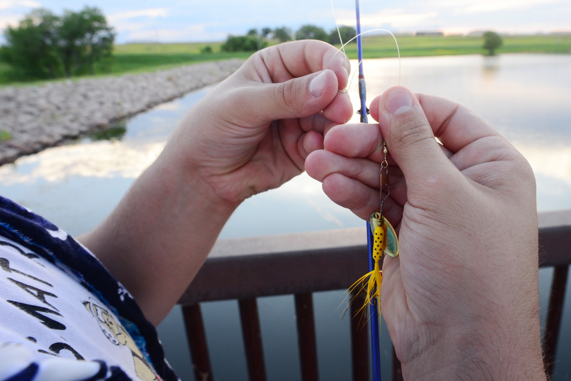 Airman John Ennis, a 28th Bomb Wing Public Affairs broadcast journalist, rigs his fishing rod at Ellsworth Air Force Base, S.D., July 12, 2018. Base fishing permits and South Dakota fishing licenses are available at Outdoor Recreation. (U.S. Air Force photo by Airman 1st Class Nicolas Z. Erwin)