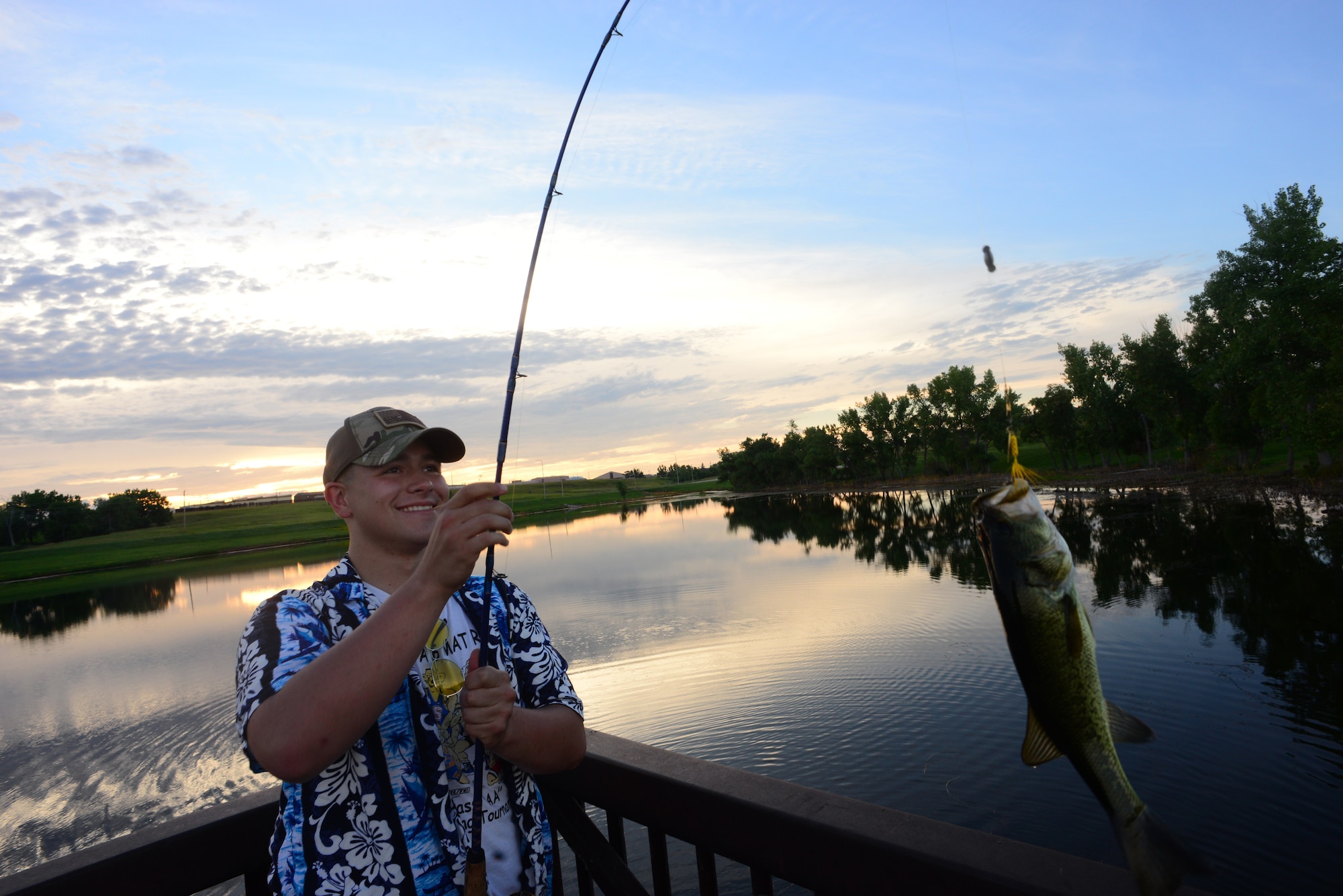 Airman John Ennis, a 28th Bomb Wing Public Affairs broadcast journalist, catches a bass at Gateway Lake on Ellsworth Air Force Base, S.D., July 12, 2018. Any person with installation access is allowed to fish at the base lakes if they have a valid South Dakota fishing license and base fishing permit. (U.S. Air Force photo by Airman 1st Class Nicolas Z. Erwin)