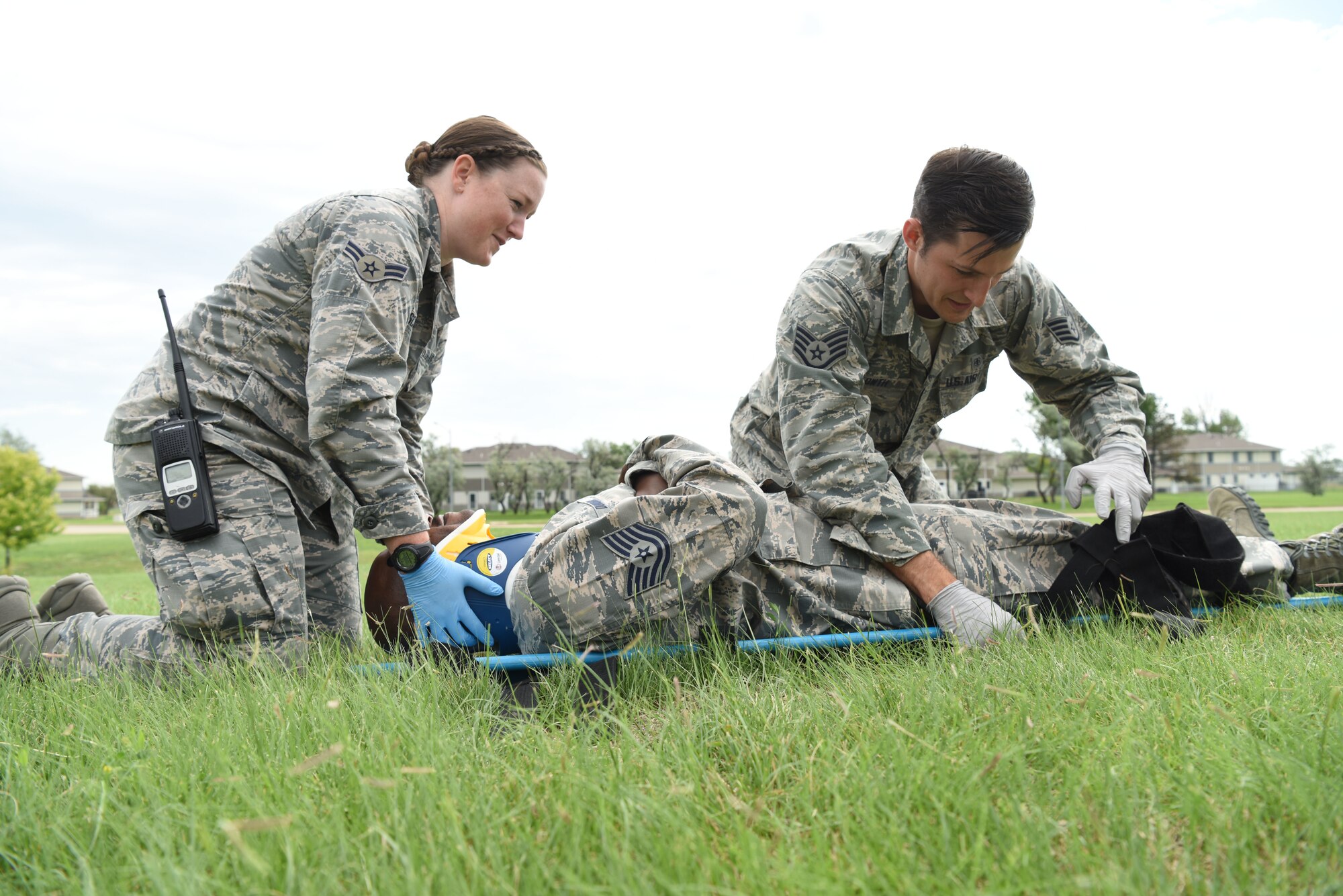 Airman 1st Class Kayla Descamps and Staff Sgt. Michael Glowth, 28th Medical Group aerospace medical technicians, practice strapping Tech. Sgt. Ricky Dunbar, the noncommissioned officer in charge of the ambulance services flight, to a stretcher at Ellsworth Air Force Base, S.D., July 10, 2018. The 28th Medical Operations Squadron ambulance services flight brings a lot of gear with them on calls so they can deal with a wide variety of situations. (U.S. Air Force photo by Airman 1st Class Thomas Karol)