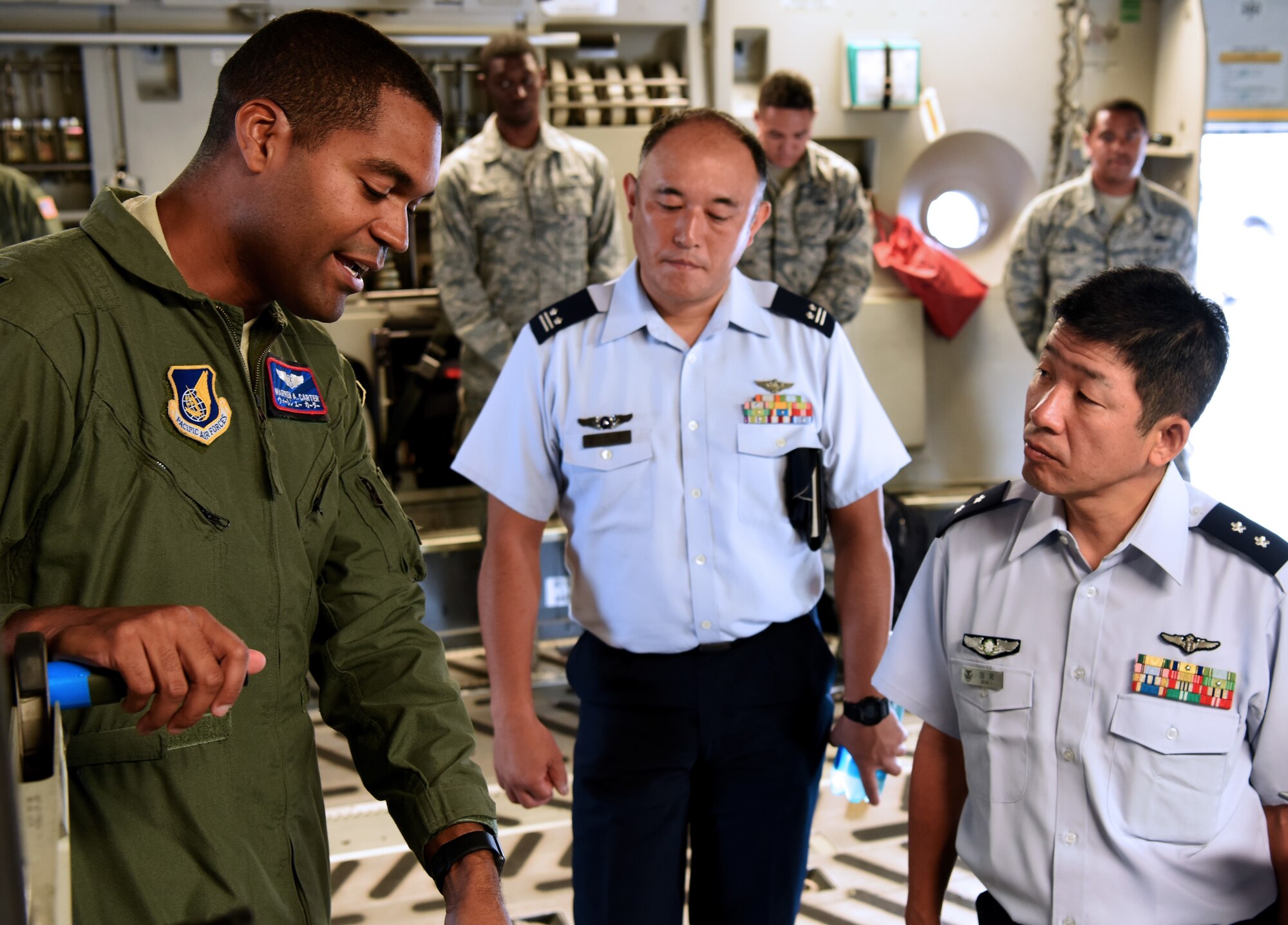 U.S. Air Force Capt. Warren Carter, Operations Element Chief, 18th Aeromedical Evacuation Squadron, Det 1, speaks with Koku Jieitai, Japan Air Self Defense Force, Maj. Gen. Shinya Bekku, Koku Jieitai Surgeon General, aboard a C-17 Globemaster III at Joint Base Pearl Harbor-Hickam, Hawaii, July 11, 2018.