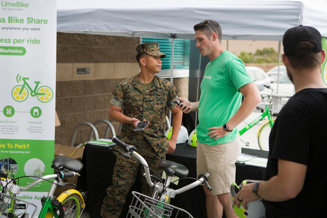 A LimeBike employee explains how to use the lime bikes to Staff Sgt. Rafael Bajada, an admin clerk with Installation Personnel Administration Center on Marine Corps Air Station Miramar, Calif., July 9.  MCAS Miramar and LimeBike, a bicycle-sharing company, worked together to bring an environmentally friendly and inexpensive transportation alternative for Marines who lack vehicle transportation or wish to save money.  (U.S. Marine Corps photo by Cpl. Victor Mincy)