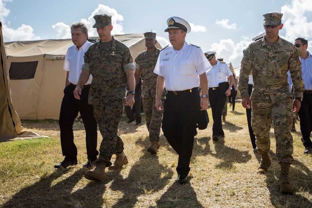 Alberto Espina, Chilean Minister of Defense, U.S. Marine Corps Brig. Gen. Mark Hashimoto, component commander, Fleet Marine Force, and Chilean Navy Adm. Julio Leiva, Chilean Navy Commander-in-Chief, explore tent city during the Rim of the Pacific (RIMPAC) exercise on Marine Corps Base Hawaii July 11, 2018. RIMPAC provides high-value training for task-organized, highly capable Marine Air-Ground Task Force and enhances the critical crisis response capability of U.S. Marines in the Pacific.