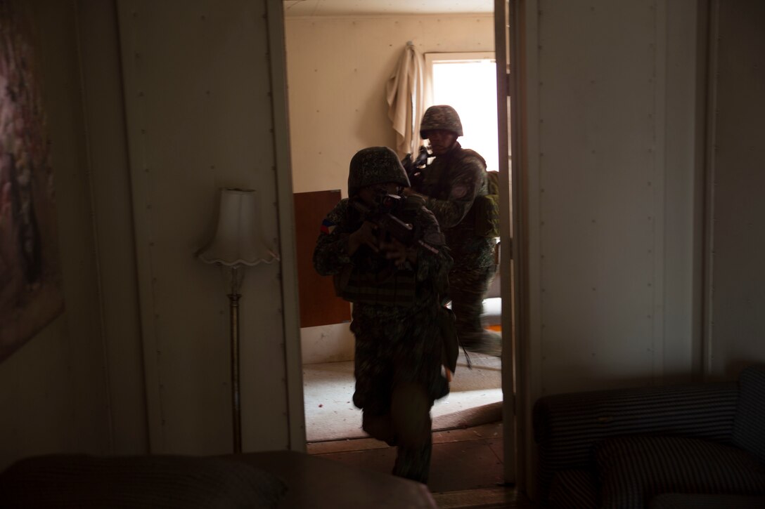 Philippine Marines clear rooms during a noncombatant evacuation operation (NEO) training event as part of Rim of the Pacific (RIMPAC) exercise at Pohakuloa Training Area, Hawaii, July 12, 2018. A NEO is conducted to evacuate citizens whose lives are in danger. RIMPAC provides high-value training for task-organized, highly capable Marine Air-Ground Task Force and enhances the critical crisis response capability of U.S. Marines in the Pacific.