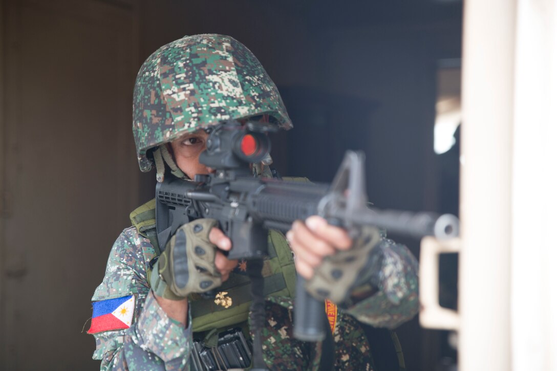 A Philippine marine sights in with an M4 carbine to observe enemy combatant role players during a noncombatant evacuation operation (NEO) training event as part of Rim of the Pacific (RIMPAC) exercise at Pohakuloa Training Area, Hawaii, July 12, 2018. A NEO is conducted to evacuate citizens whose lives are in danger. RIMPAC provides high-value training for task-organized, highly capable Marine Air-Ground Task Force and enhances the critical crisis response capability of U.S. Marines in the Pacific.