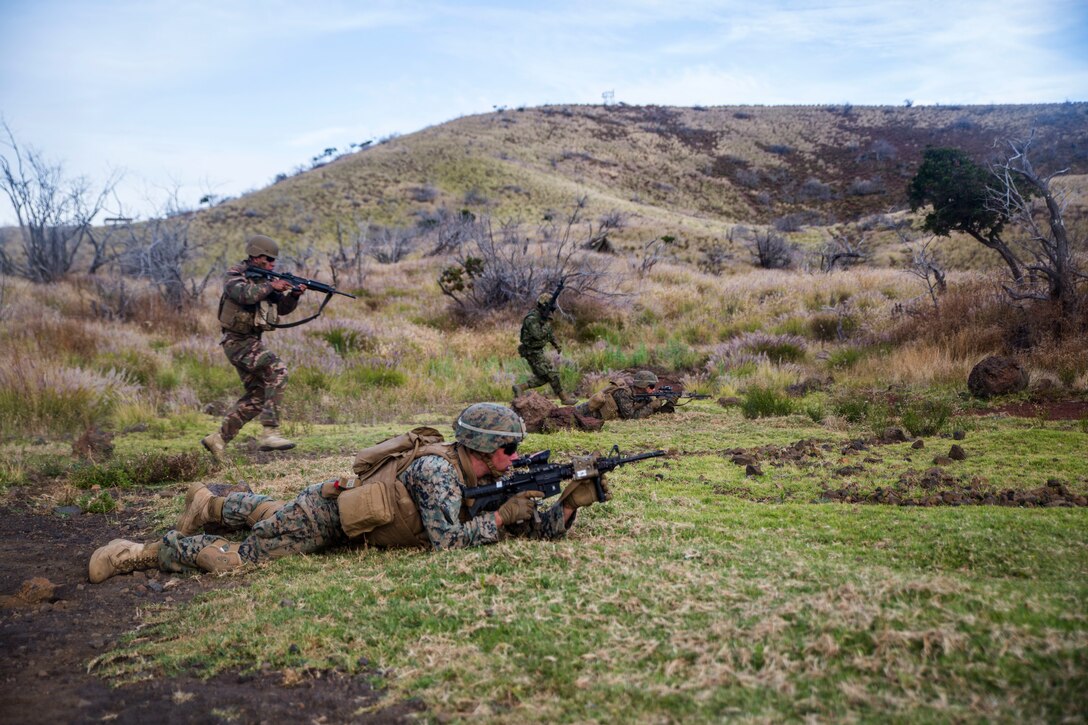 U.S. Marines and marines with the Royal Tongan Marine Infantry rush towards an objective during a live-fire training event as part of Rim of the Pacific (RIMPAC) exercise at Pohakuloa Training Area, Hawaii, July 13, 2018. The live-fire training integrated other RIMPAC participants with U.S. Marines to create fire teams, which provides high-value training for task-organized, highly capable Marine Air-Ground Task Force and enhances the critical crisis response capability of U.S. Marines in the Pacific.