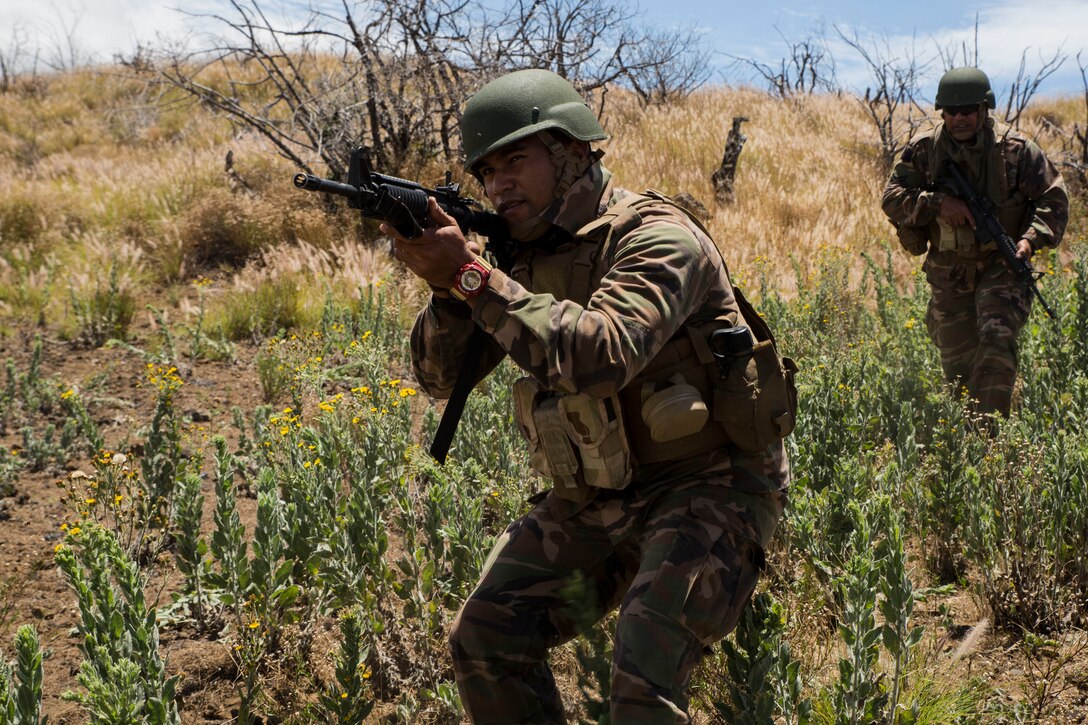 Tongan Marine Pvt. Saimi Faasee with the Royal Tongan Marine Infantry advances towards an objective during a live-fire training event during Rim of the Pacific (RIMPAC) exercise at Pohakuloa Training Area, Hawaii, July 13, 2018. The live-fire training integrated fire teams from other RIMPAC participants with U.S. Marines, which provides high-value training for task-organized, highly capable Marine Air-Ground Task Force and enhances the critical crisis response capability of U.S. Marines in the Pacific.
