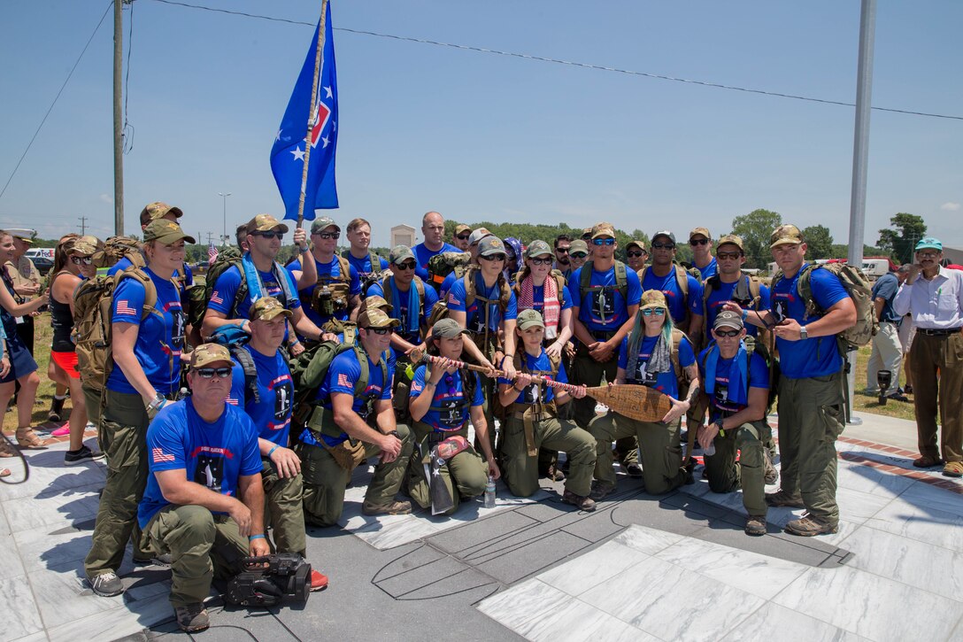 The Rucking Raiders pose for a picture at the Memorial Marker, after the dedication ceremony, before beginning the 900 mile ruck march from Greenwood, Miss. To Camp Lejeune, N.C., on July 14, 2018. The Rucking Raiders, consisting of 4 rotating teams, are carrying dirt from the crash site of the fallen Marines and Sailor, back to the home station of Camp Lejeune, N.C. (U.S. Marine Corps photo by Lance Cpl. Samantha Schwoch/released)