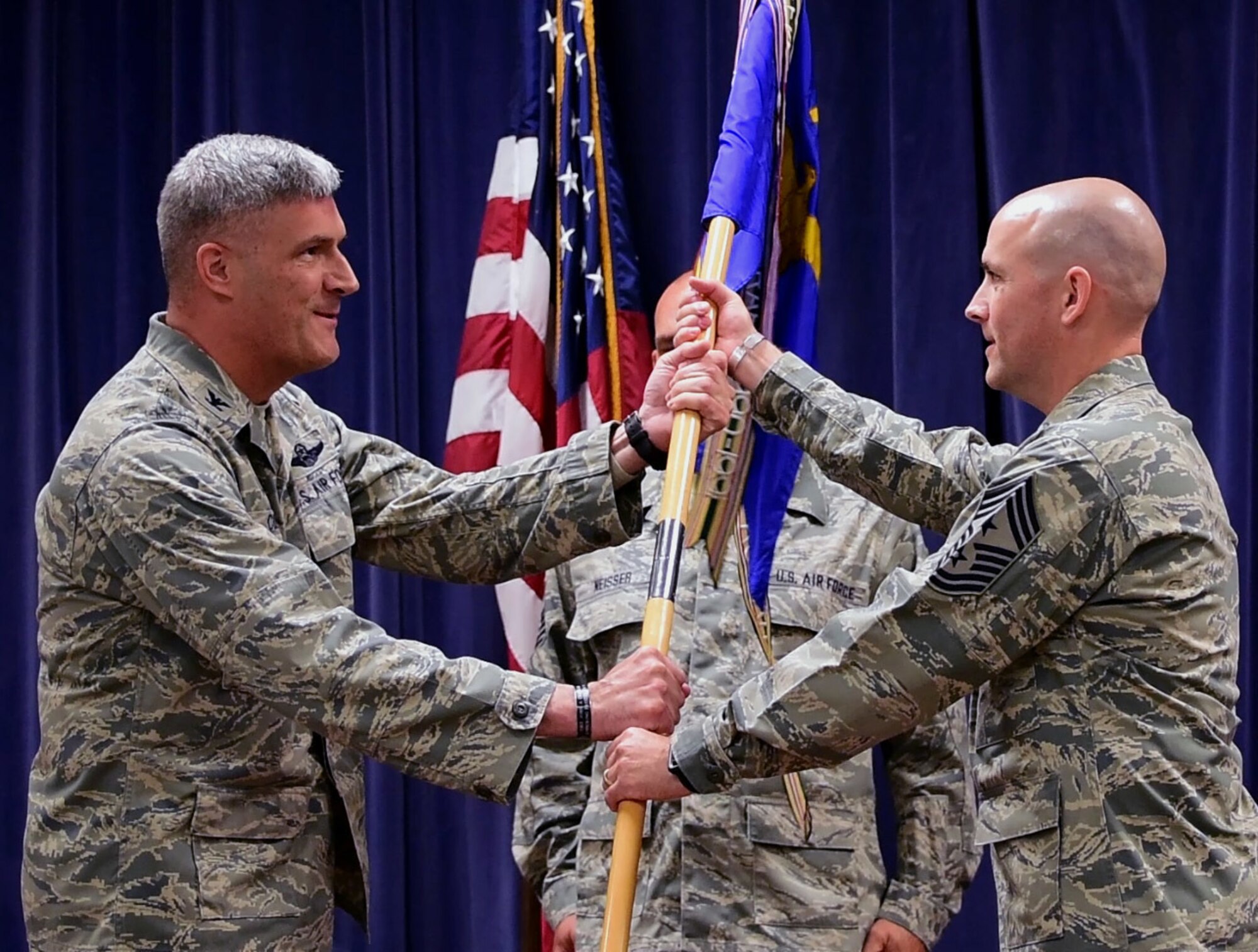 Outgoing 166th Airlift Wing Command Chief Master Sgt. Shaune Peters, left, looks on as her successor, Command Chief Master Sgt. William Horay, is introduced during their change of authority ceremony held at the New Castle ANG Base, Del. on July 14, 2018. (U.S. Air National Guard photo by Staff Sgt. Nathan Bright)