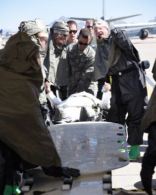 Members of the 161st Air Refueling Wing receive a patient to process through an In-Place Patient Decontamination station during an exercise at the Goldwater Air National Guard Base, May 22. The purpose of the exercise was to train and evaluate the IPPD team's ability to decontaminate and prepare a patient to be transported onto a higher level of medical care. (U.S. Air National Guard photo by Staff Sgt. Wes Parrell)