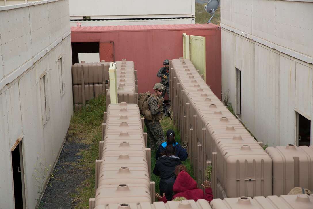 A U.S. Marine leads civilian role players to safety during a noncombatant evacuation operation (NEO) training event as part of Rim of the Pacific (RIMPAC) exercise at Pohakuloa Training Area, Hawaii, July 12, 2018. A NEO is conducted to evacuate citizens whose lives are in danger. RIMPAC provides high-value training for task-organized, highly capable Marine Air-Ground Task Force and enhances the critical crisis response capability of U.S. Marines in the Pacific.