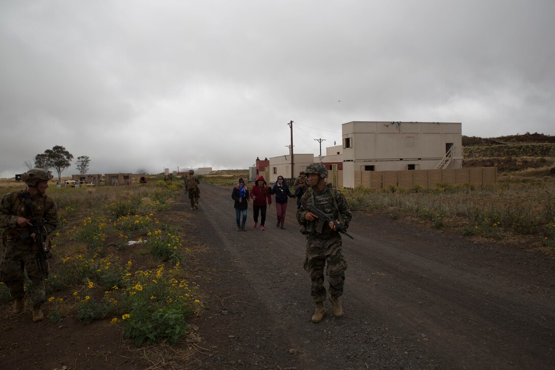 Republic of Korea and U.S. Marines provide security for civilian role players during a noncombatant evacuation operation (NEO) training event as part of Rim of the Pacific (RIMPAC) exercise at Pohakuloa Training Area, Hawaii, July 12, 2018. A NEO is conducted to evacuate citizens whose lives are in danger. RIMPAC provides high-value training for task-organized, highly capable Marine Air-Ground Task Force and enhances the critical crisis response capability of U.S. Marines in the Pacific.