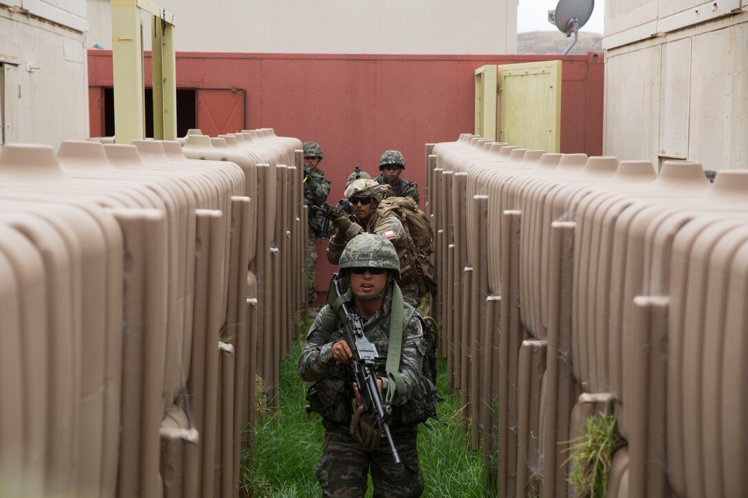 Republic of Korea, Chilean and U.S. Marines patrol through a corridor during a noncombatant evacuation operation (NEO) training event as part of Rim of the Pacific (RIMPAC) exercise at Pohakuloa Training Area, Hawaii, July 12, 2018. A NEO is conducted to evacuate citizens whose lives are in danger. RIMPAC provides high-value training for task-organized, highly capable Marine Air-Ground Task Force and enhances the critical crisis response capability of U.S. Marines in the Pacific.