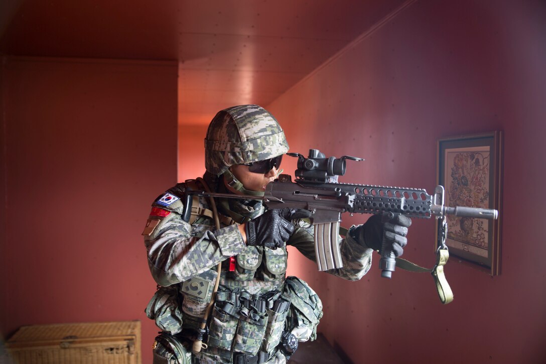A Republic of Korea marine clears a building during a noncombatant evacuation operation (NEO) training event as part of Rim of the Pacific (RIMPAC) exercise at Pohakuloa Training Area, Hawaii, July 12, 2018. A NEO is conducted to evacuate citizens whose lives are in danger. RIMPAC provides high-value training for task-organized, highly capable Marine Air-Ground Task Force and enhances the critical crisis response capability of U.S. Marines in the Pacific.