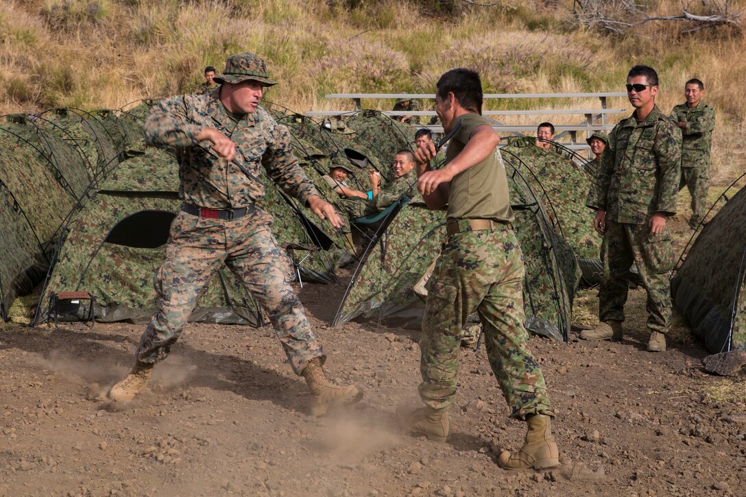 Japan Ground Self-Defense Force Sgt. 1st Class Masakatsu Sugimoto, right, a samurai martial arts instructor with 2nd Amphibious Rapid Deployment Regiment, and U.S. Marine Corps 1st. Sgt. William Radebaugh, company first sergeant, Bravo Company, 1st Battalion, 3rd Marine Regiment, spar with each other while waiting for the next training event during Rim of the Pacific (RIMPAC) exercise at Pohakuloa Training Area, Hawaii, July 13, 2018. RIMPAC provides high-value training for task-organized, highly capable Marine Air-Ground Task Force and enhances the critical crisis response capability of U.S. Marines in the Pacific.