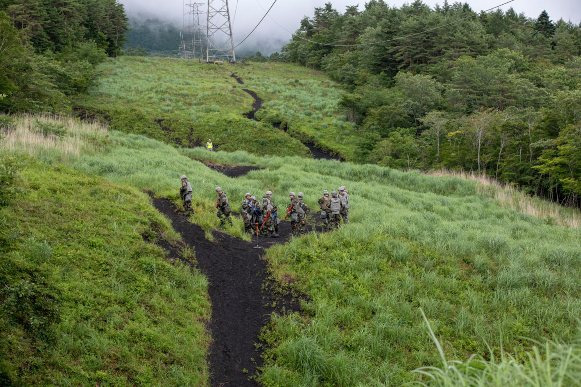 Airmen with the 374th Airlift Wing take a break over the hill during Chemical, Biological, Radiological and Nuclear training