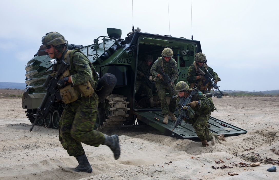 Canadian soldiers with the Royal 22e Régiment exit an AAV-P7/A1 assault amphibious vehicle during an amphibious raid as part of Rim of the Pacific (RIMPAC) exercise on Marine Corps Base Camp Pendleton, California, July 13, 2018. This evolution provided an opportunity for participating nations to share best practices which included loading and unloading drills as well as squad attacks. RIMPAC demonstrates the value of amphibious forces and provides high-value training for task-organized, highly capable Marine Air-Ground Task Forces enhancing the critical crisis response capability of U.S. forces and partners globally.