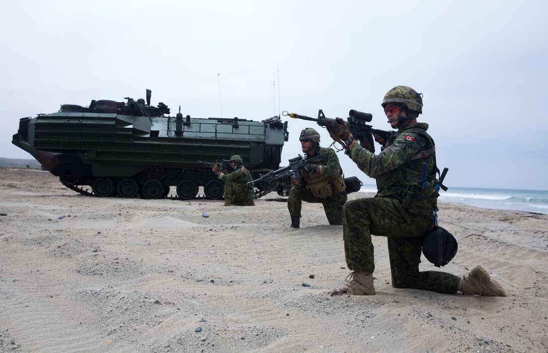 Canadian soldiers with the Royal 22e Régiment, post security during an amphibious raid as part of Rim of the Pacific (RIMPAC) exercise on Marine Corps Base Camp Pendleton, California, July 13, 2018. This evolution provided an opportunity for participating nations to share best practices which included loading and unloading drills as well as squad attacks. RIMPAC demonstrates the value of amphibious forces and provides high-value training for task-organized, highly capable Marine Air-Ground Task Forces enhancing the critical crisis response capability of U.S. forces and partners globally. Twenty-five nations, 46 ships, five submarines, about 200 aircraft and 25,000 personnel are participating in RIMPAC from June 27 to Aug. 2 in and around the Hawaiian Islands and Southern California. (U.S. Marine Corps photo by Cpl. Robert G. Gavaldon)