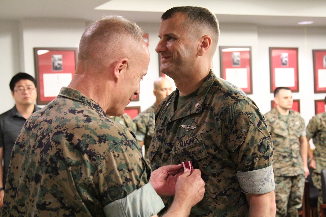 USAG CAMP HUMPHREYS, Korea – Maj. Gen. Patrick J. Hermesmann (left), commander of U.S. Marine Corps Forces Korea, awards Lt. Col. Larry A. Bailey, MARFORK G3 Operations assistant chief of staff, a Meritorious Service Medal here, July 9.  Bailey, a native of Tenino, Wash., plans to retire from the Marine Corps after 24 years of service and teach high school physics in his hometown. (Official U.S. Marine Corps photo by Staff Sgt. Anthony Kirby/Released)