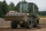 Sgt. Zac Hartley, a horizontal construction engineer in the West Virginia Army National Guard, assigned to 812th Engineer Company, 1092nd Engineer Battalion, 111th Engineer Brigade based out of Eleanor, West Virginia, operates a front end loader to place gravel at Drawsko Pomorskie Training Area, Poland, during Resolute Castle, July 12, 2018.