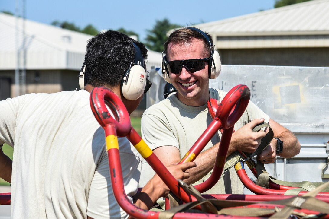 U.S. Air Force Senior Airman Zachary Moore, right, and Senior Airman Daniel Abbiati, 20th Aircraft Maintenance Squadron support technicians, interact on the flight line at Shaw Air Force Base, S.C., July 11, 2018.
