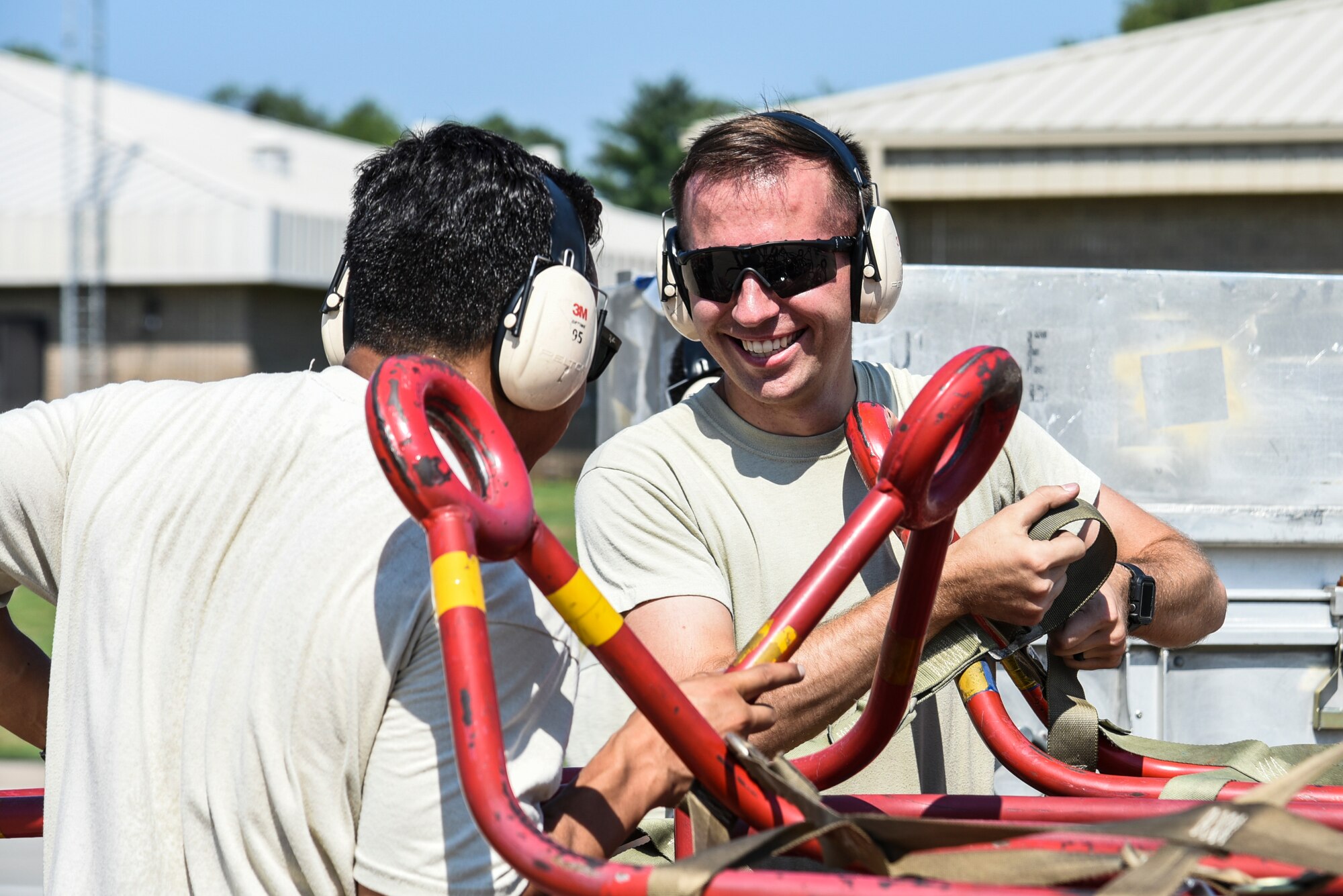 U.S. Air Force Senior Airman Zachary Moore, right, and Senior Airman Daniel Abbiati, 20th Aircraft Maintenance Squadron support technicians, interact on the flight line at Shaw Air Force Base, S.C., July 11, 2018.