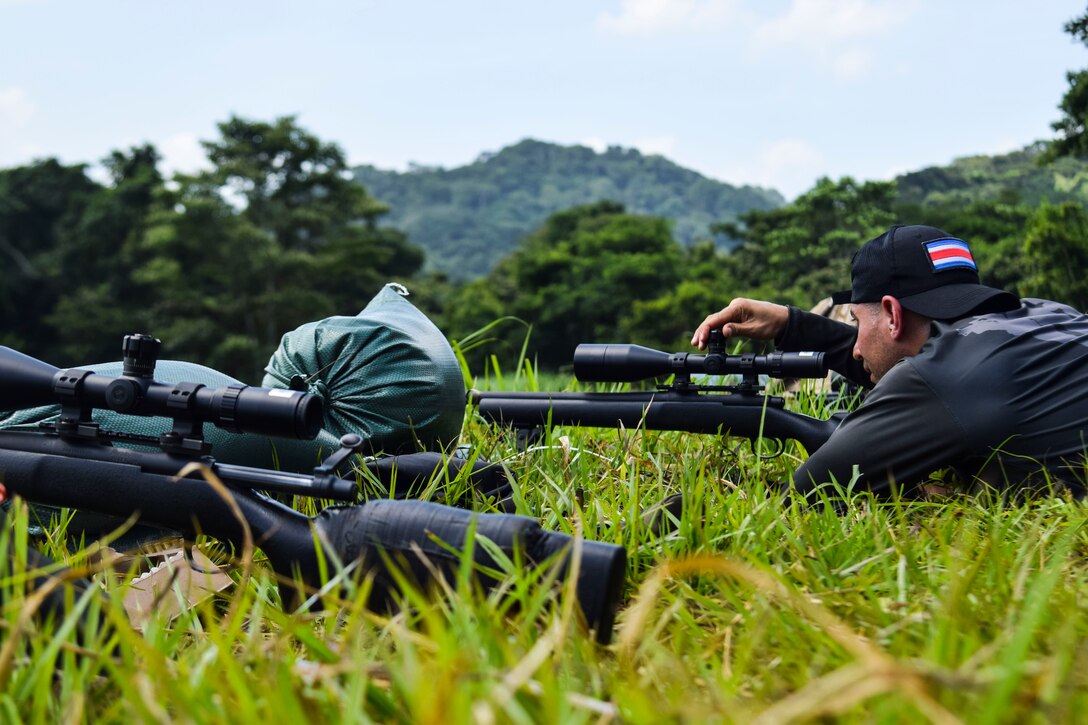 A Costa Rican troop adjusts his sniper rifle.